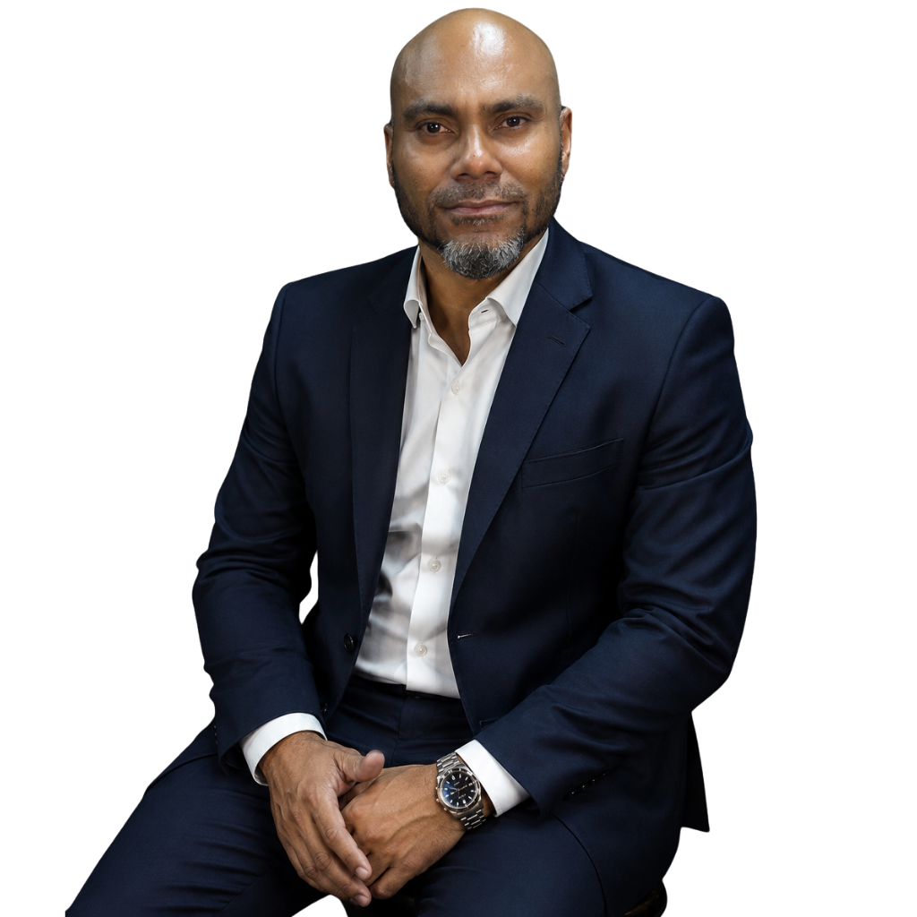 Retrato jovem homem negro, de executivo sentado, olhando para a câmera com expressão séria, em ambiente corporativo minimalista.